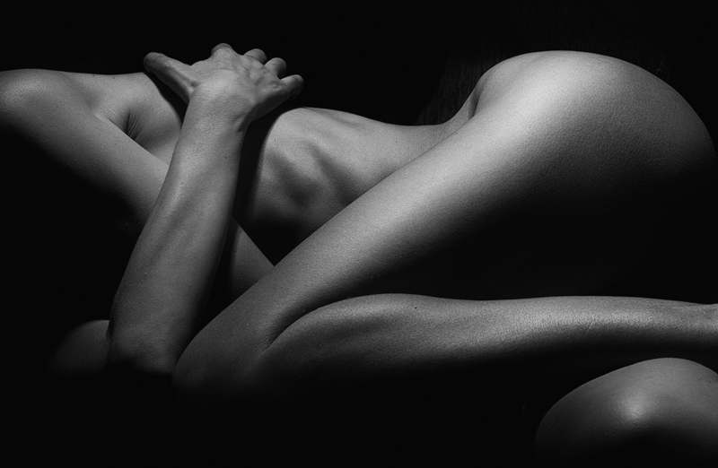 Close-up of hands applying a creamy, ivory-toned body moisturizer to forearm with visible smooth, hydrated skin